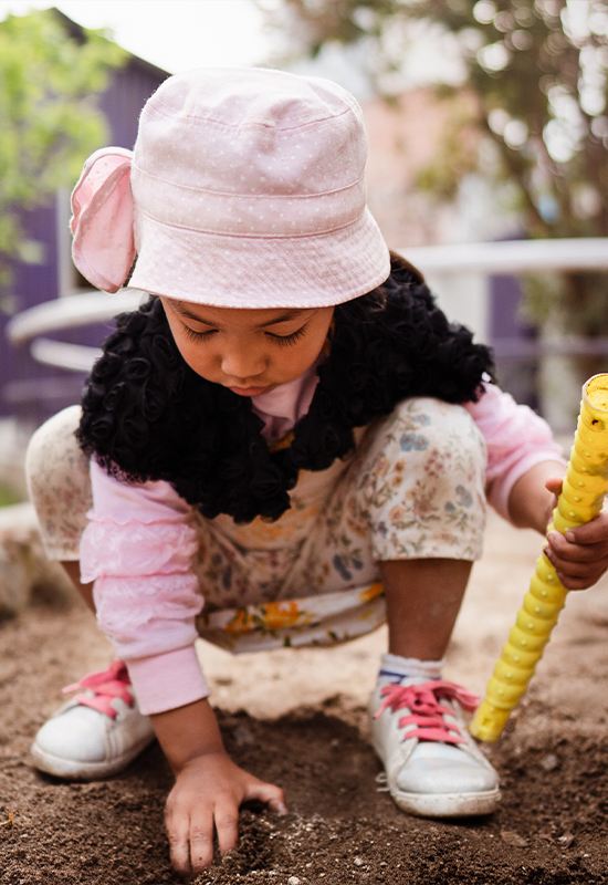 Little girl playing in dirt