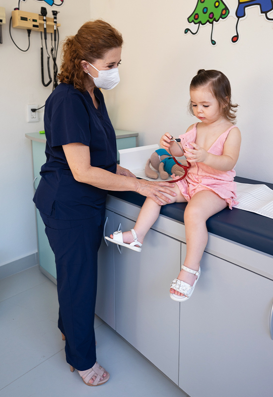 Young girl sitting on the doctors table being seen