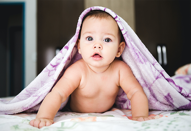 Baby on floor under blanket
