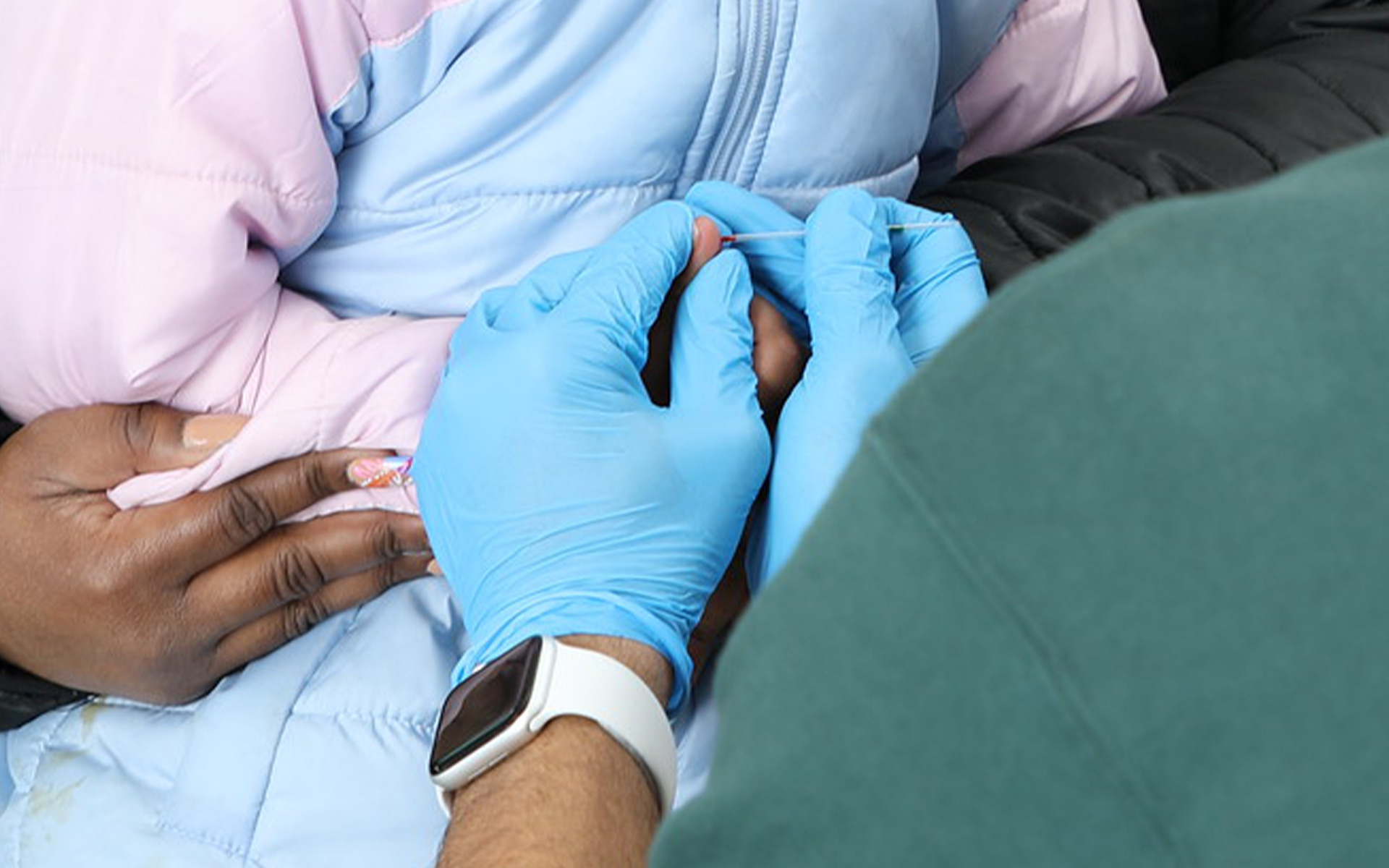 Close up of a mother holding her child while getting a finger prick blood test to test for lead